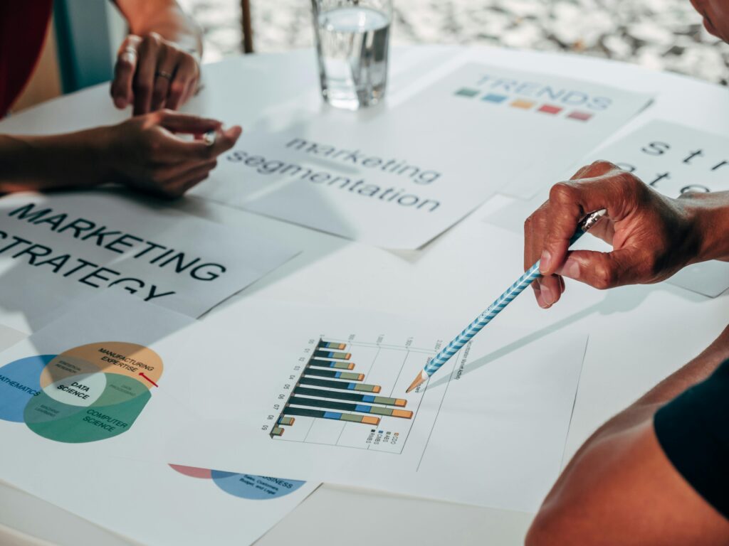Performance marketing strategist analyzing data charts and marketing segmentation data during a business strategy meeting.